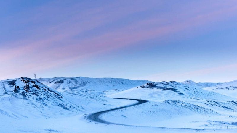 winter road trip in Iceland in snow and pink skies