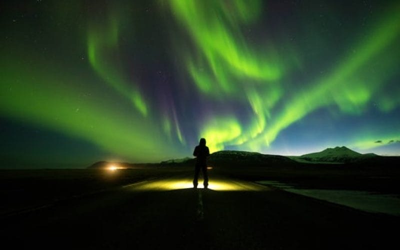 Northern Lights Iceland | Iceland Travel Guide, man watching the northern lights in Iceland
