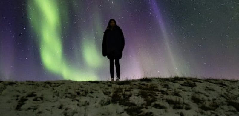 man watching the northern lights in Iceland