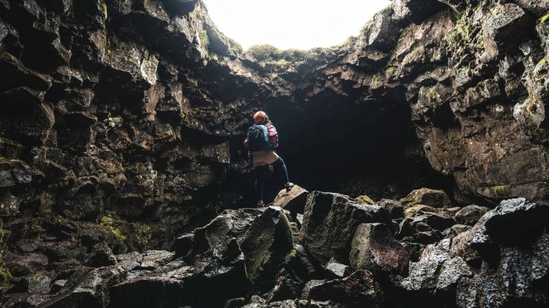 woman standing inside a lava cave in Iceland